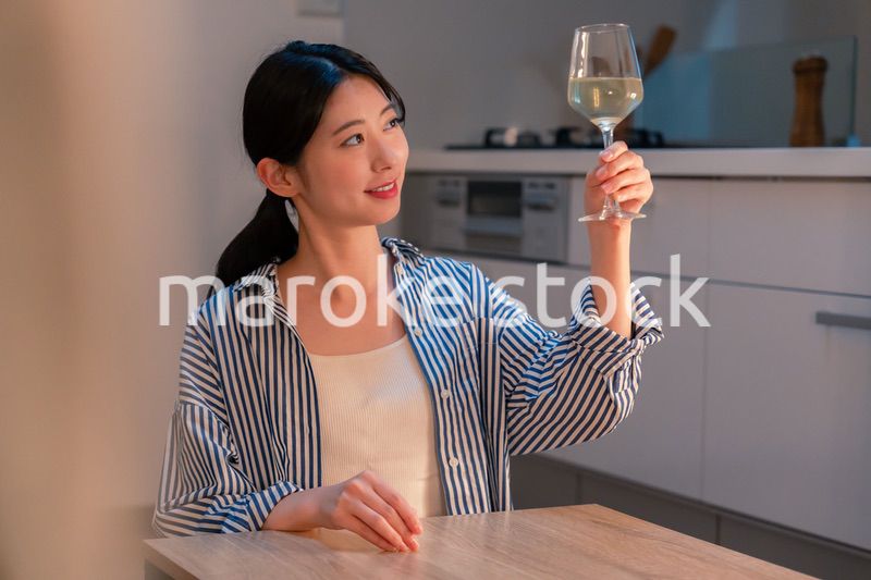 家でワインを楽しむ一人暮らしの女性