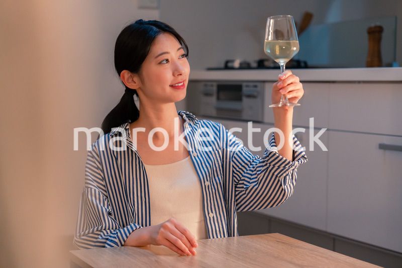 家でワインを楽しむ一人暮らしの女性