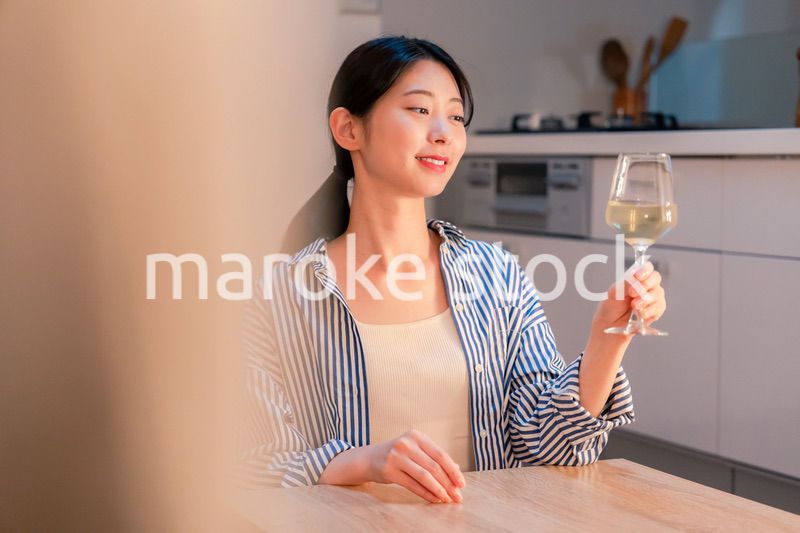 家でワインを楽しむ一人暮らしの女性