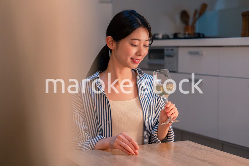 家でワインを楽しむ一人暮らしの女性