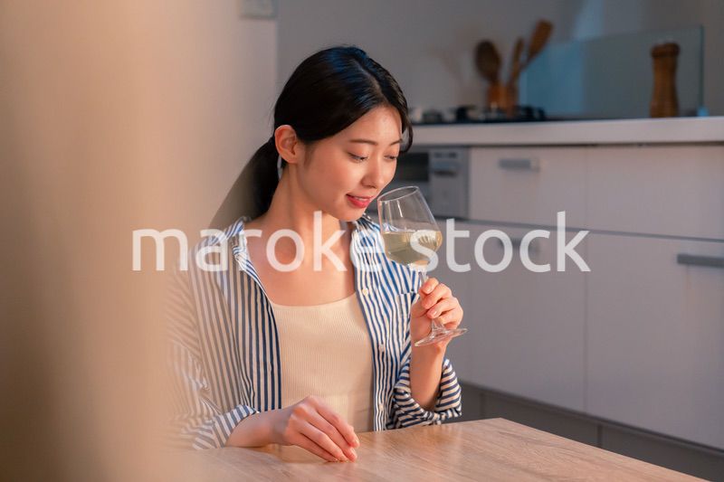 家でワインを楽しむ一人暮らしの女性