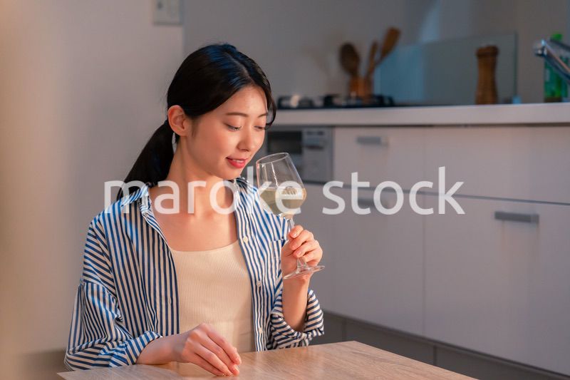 家でワインを楽しむ一人暮らしの女性