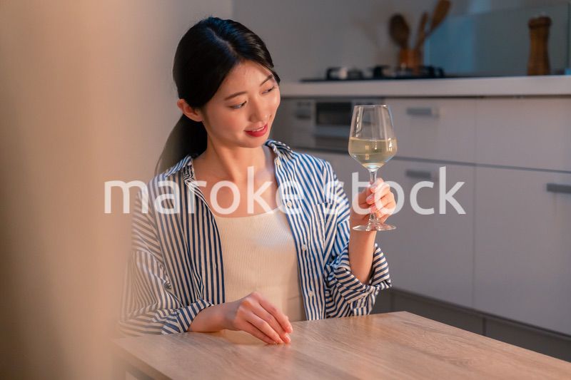 家でワインを楽しむ一人暮らしの女性