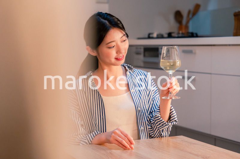 家でワインを楽しむ一人暮らしの女性