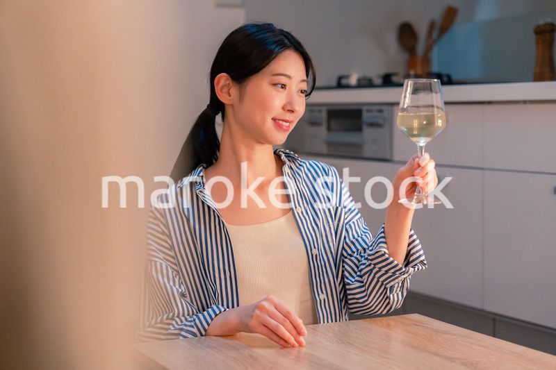 家でワインを楽しむ一人暮らしの女性