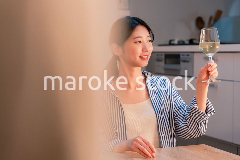 家でワインを楽しむ一人暮らしの女性