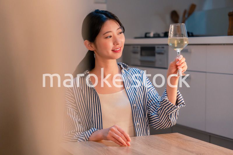 家でワインを楽しむ一人暮らしの女性