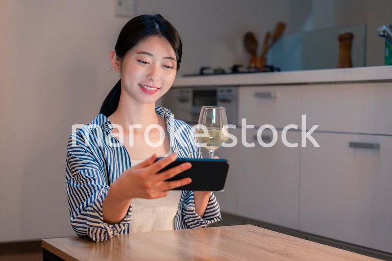 夜に一人で晩酌をする若い女性