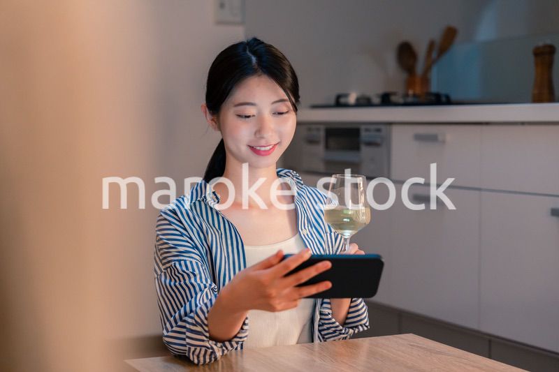 夜に一人で晩酌をする若い女性