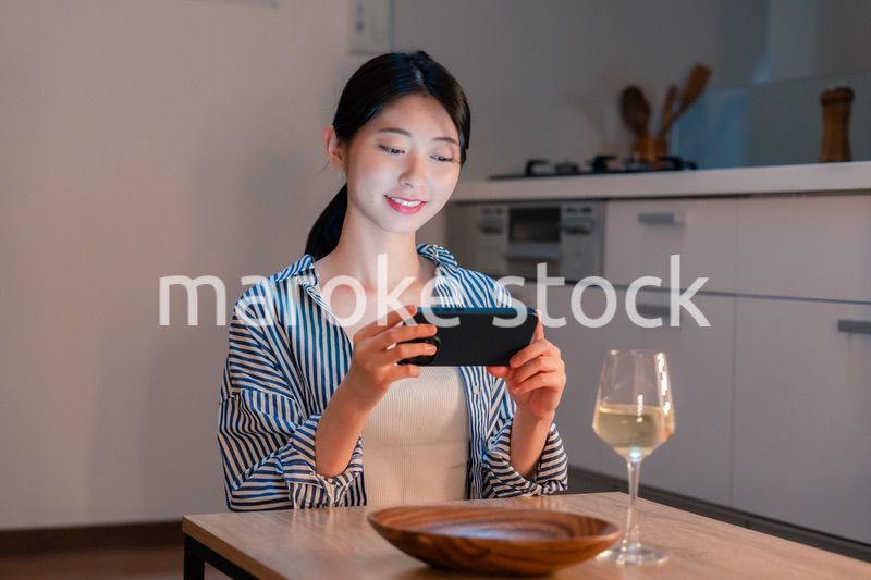 夜に一人で晩酌をする若い女性