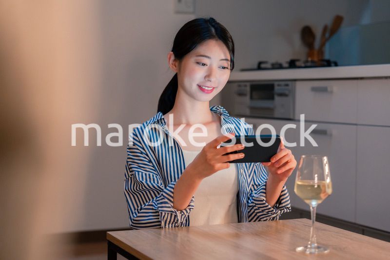 夜に一人で晩酌をする若い女性