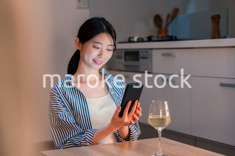 夜に一人で晩酌をする若い女性