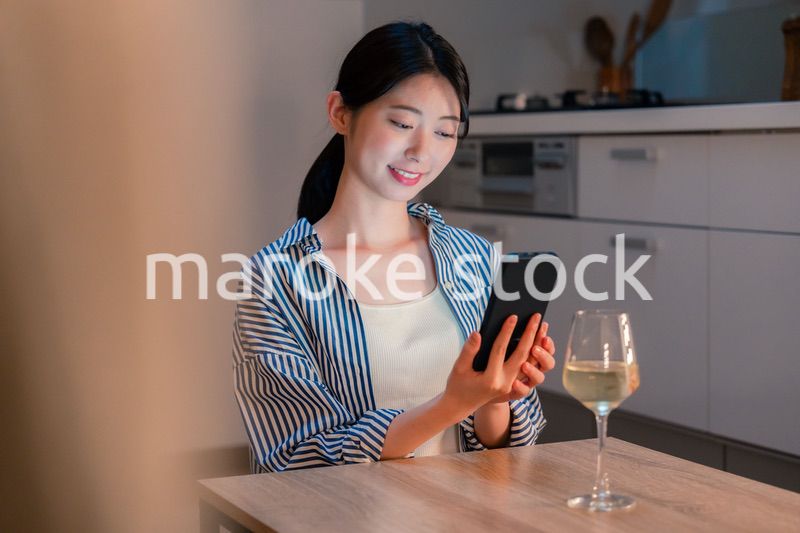 夜に一人で晩酌をする若い女性