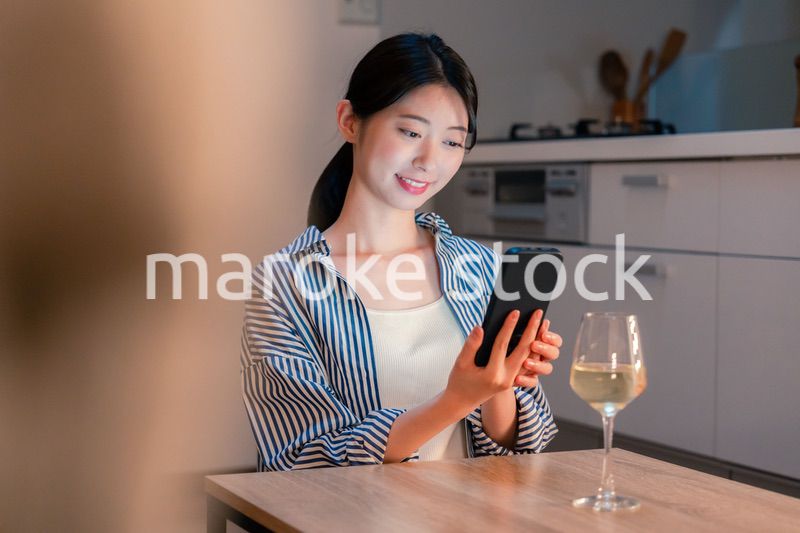 夜に一人で晩酌をする若い女性