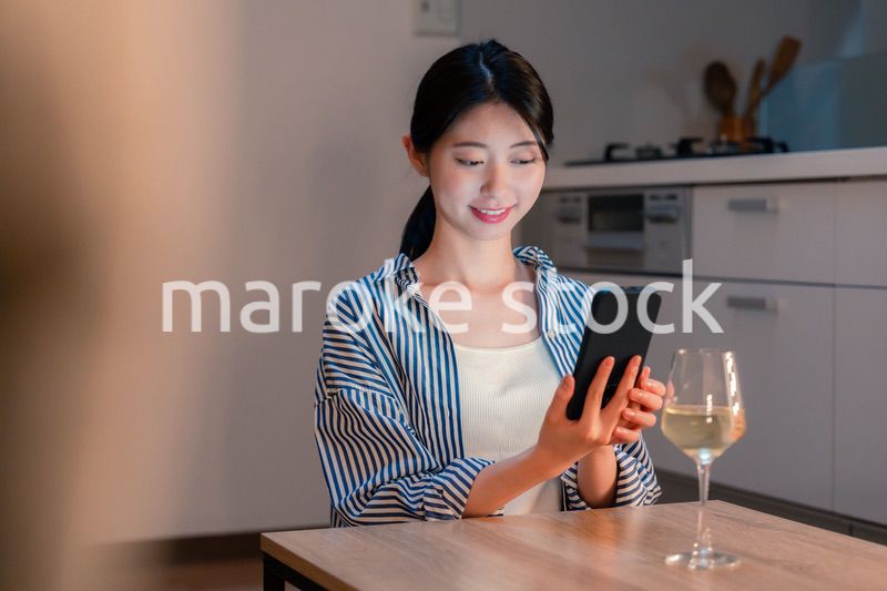 夜に一人で晩酌をする若い女性