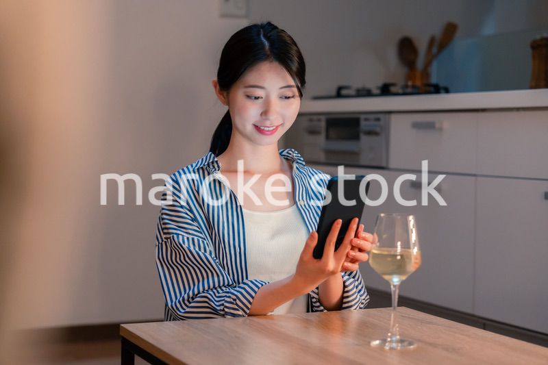 夜に一人で晩酌をする若い女性