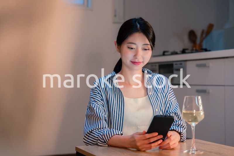 夜に一人で晩酌をする若い女性