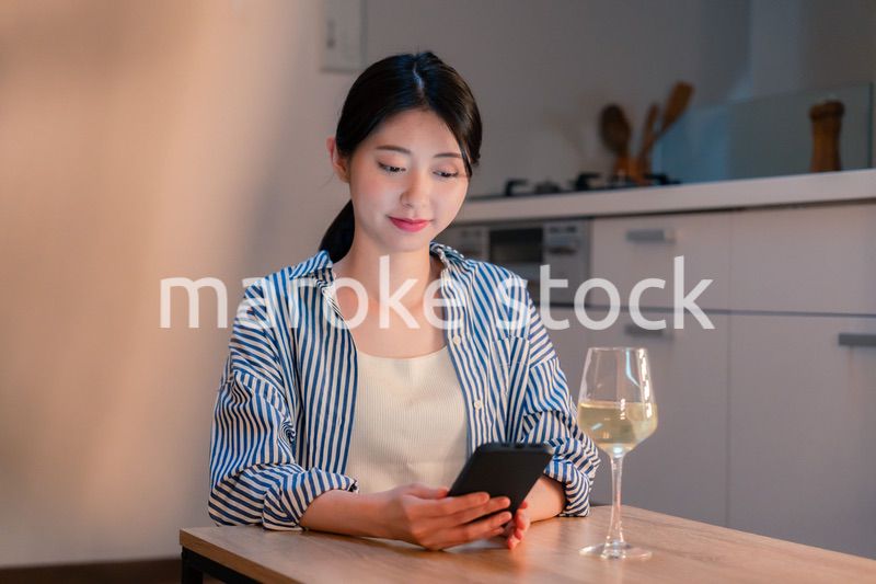 夜に一人で晩酌をする若い女性