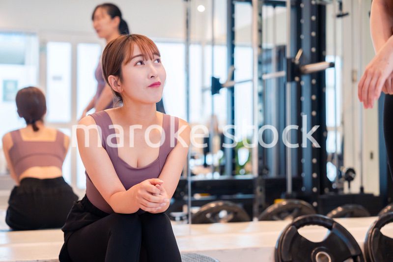 ジムで運動をしながら楽しく話をする女性