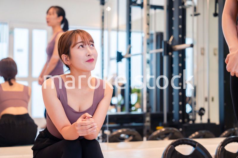 ジムで運動をしながら楽しく話をする女性