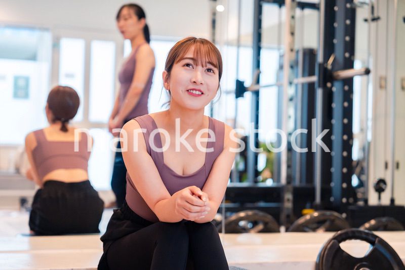 ジムで運動をしながら楽しく話をする女性