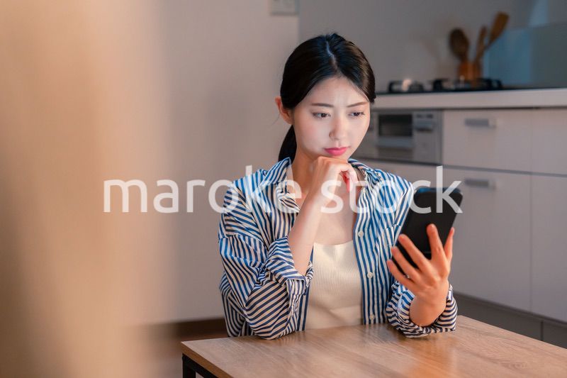 スマホを使いながら困った表情をする若い女性