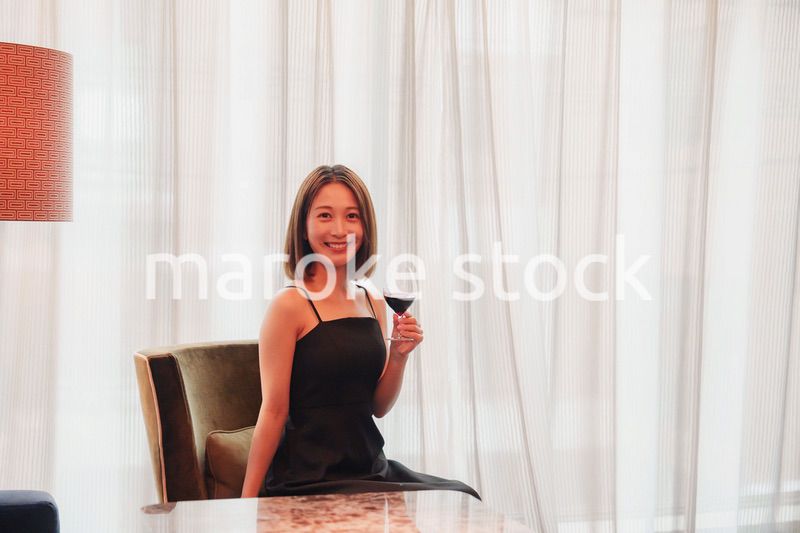 ホテルの客室でワインを楽しむ大人の女性