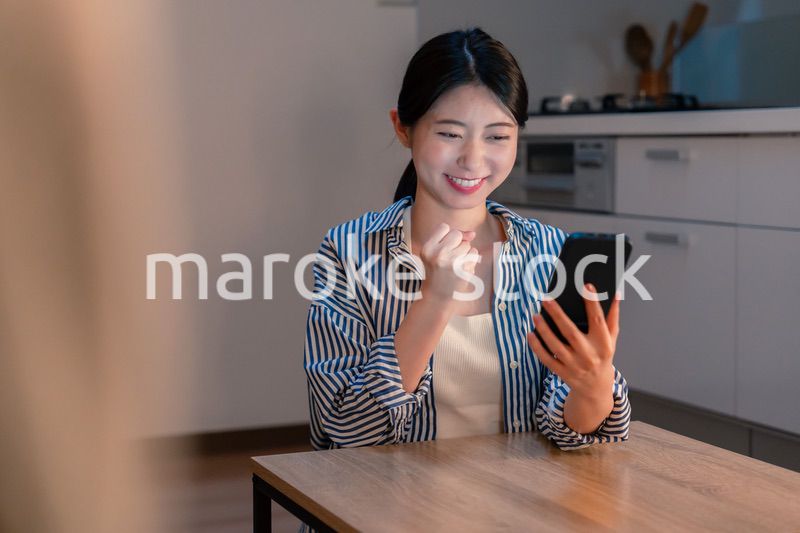 スマホを見ながら応援をする若い女性