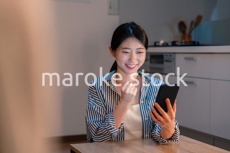 スマホを見ながら応援をする若い女性