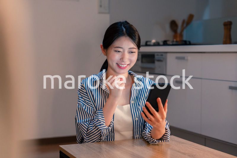 スマホを見ながら応援をする若い女性