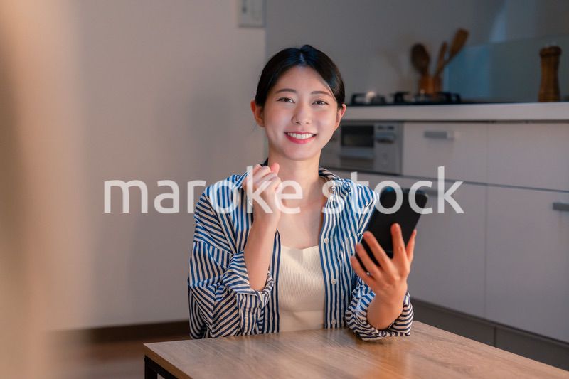 スマホを見ながら応援をする若い女性