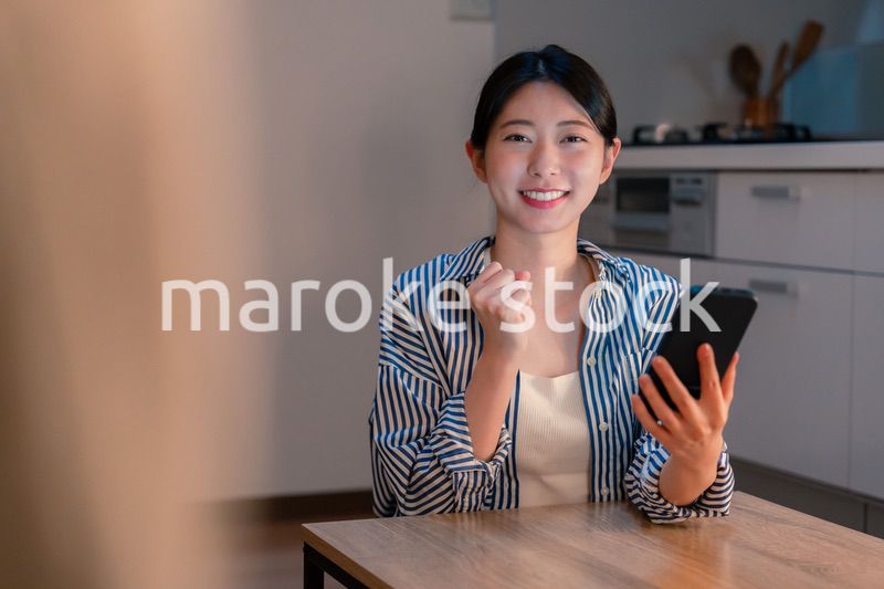 スマホを見ながら応援をする若い女性