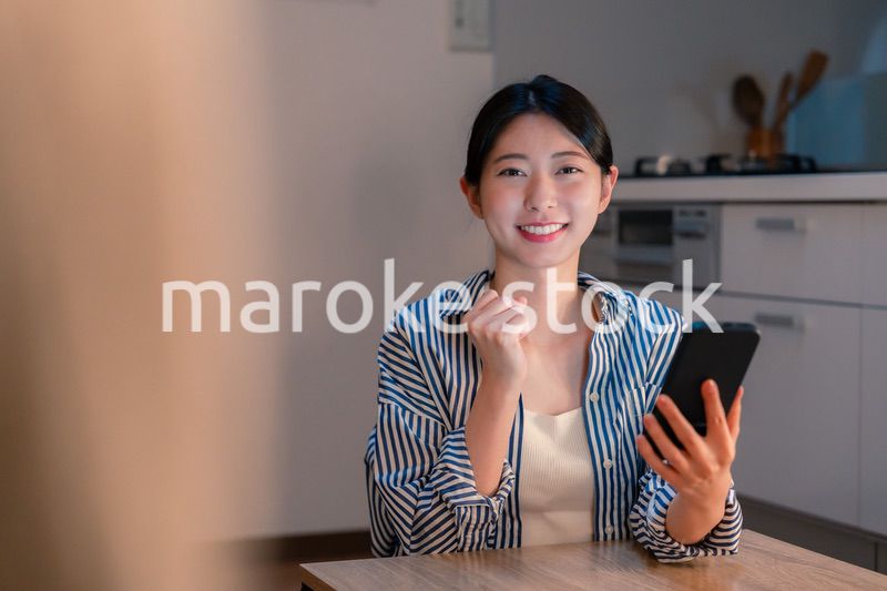 スマホを見ながら応援をする若い女性