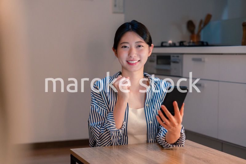 スマホを見ながら応援をする若い女性