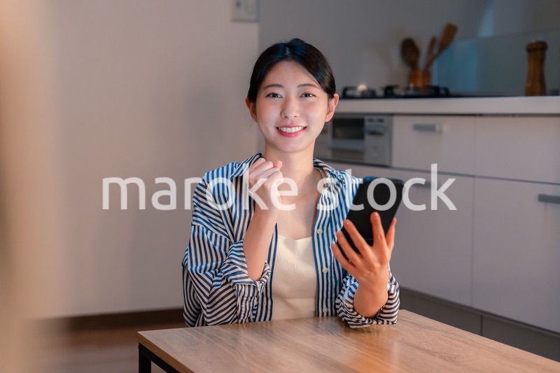 スマホを見ながら応援をする若い女性