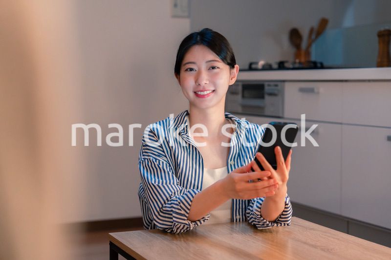 夜遅くに笑顔でスマホを使う若い女性