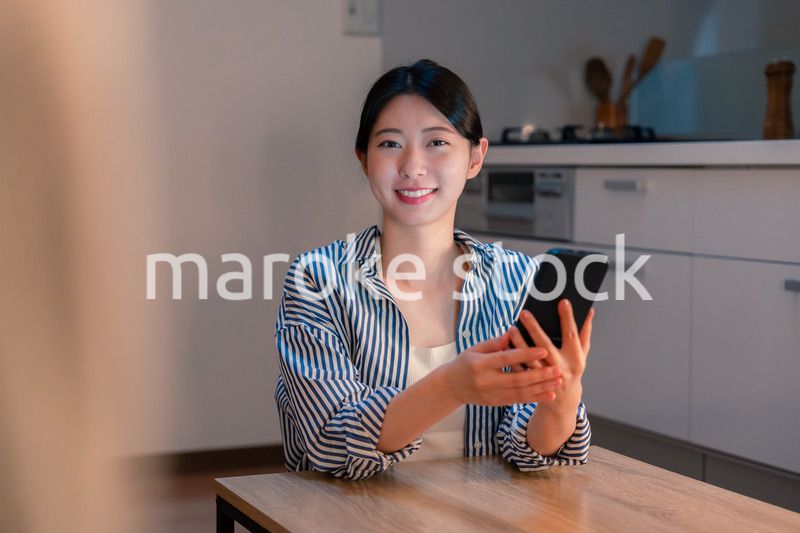 夜遅くに笑顔でスマホを使う若い女性