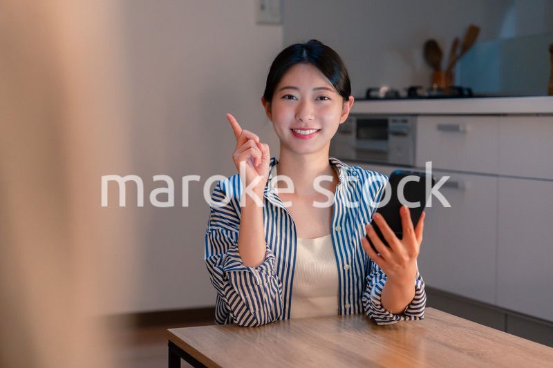 夜遅くに笑顔でスマホを使う若い女性