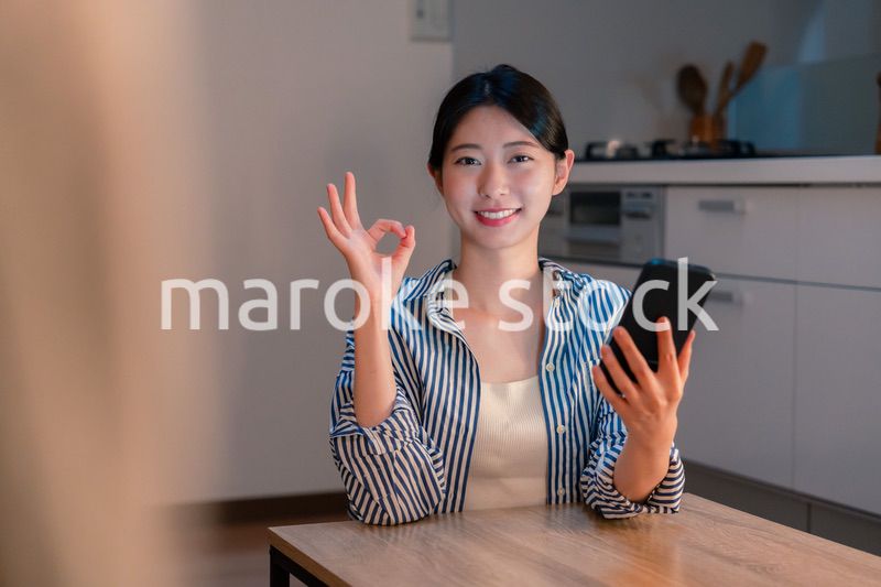 夜遅くに笑顔でスマホを使う若い女性