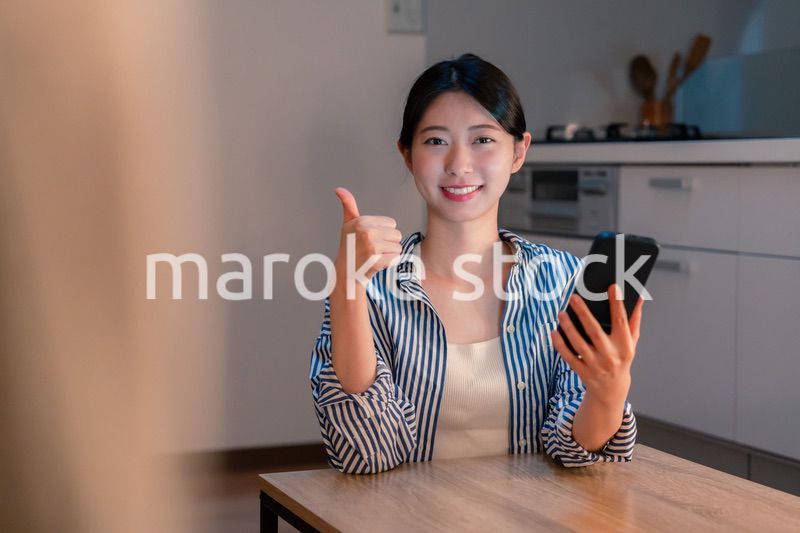 夜遅くに笑顔でスマホを使う若い女性