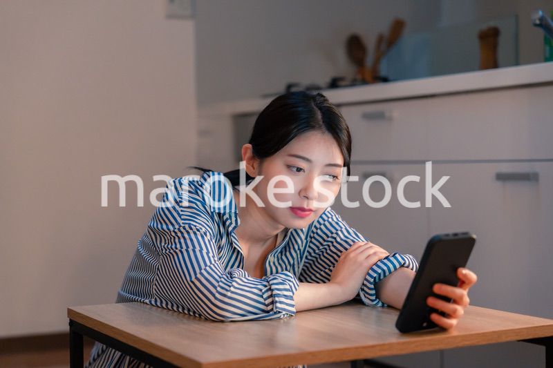 スマホを使いながら困った表情をする若い女性