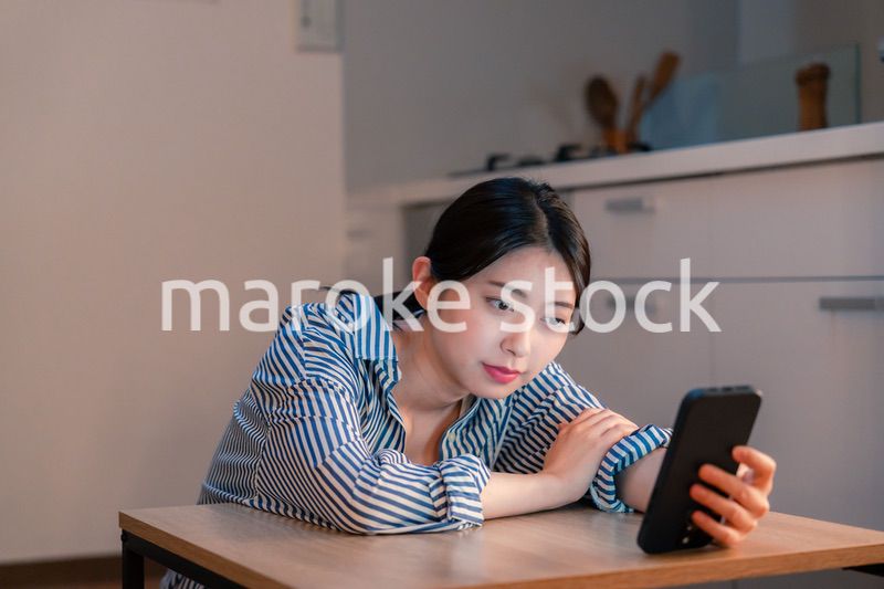 スマホを使いながら困った表情をする若い女性