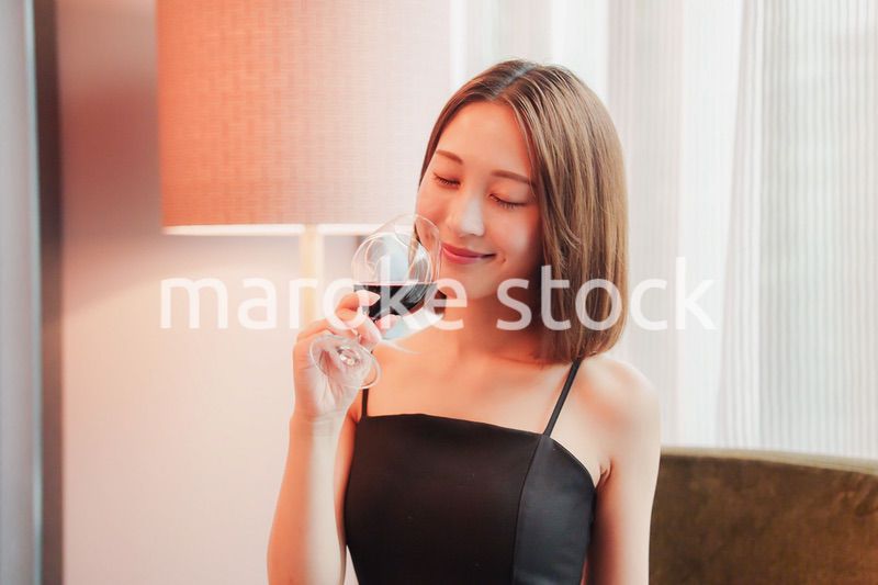 ホテルの客室でワインを楽しむ大人の女性