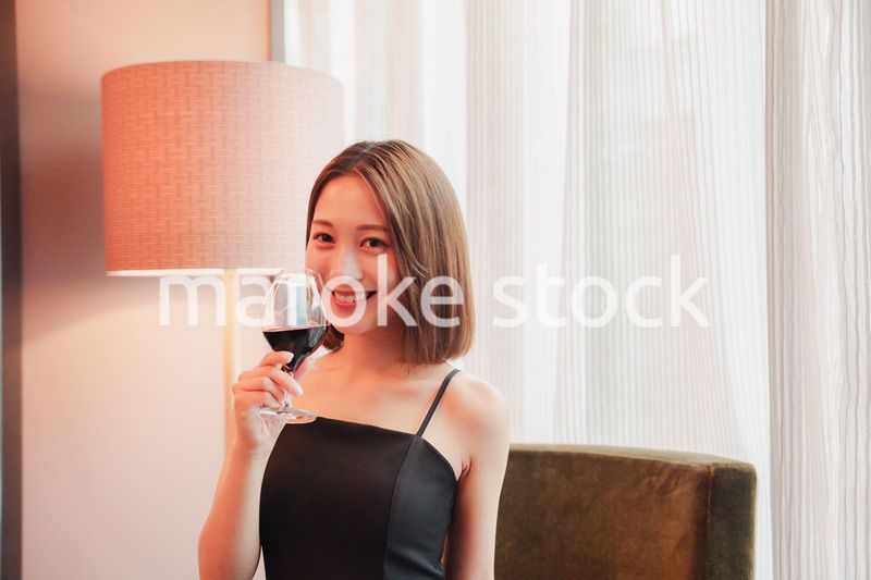 ホテルの客室でワインを楽しむ大人の女性