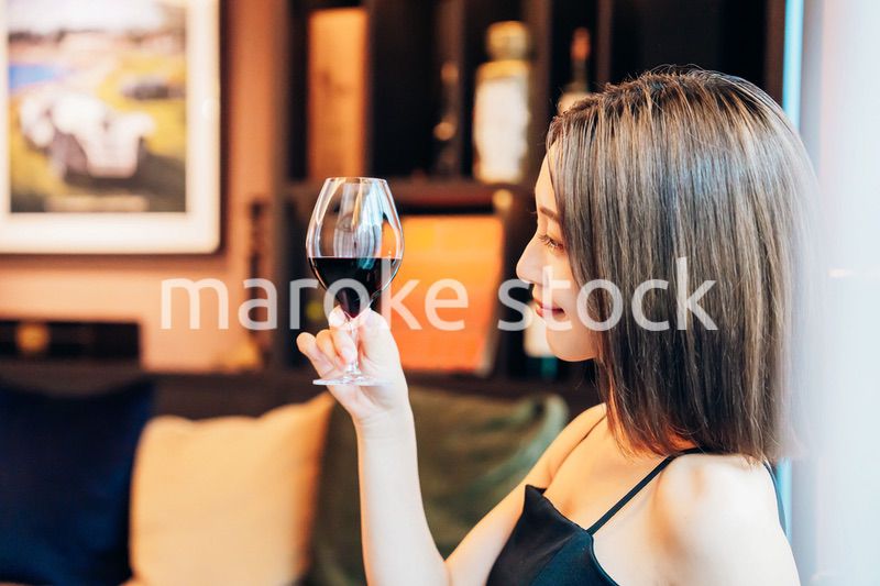 ラグジュアリーな雰囲気のお店で赤ワインを飲む若い女性