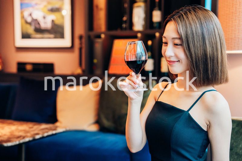 ラグジュアリーな雰囲気のお店で赤ワインを飲む若い女性