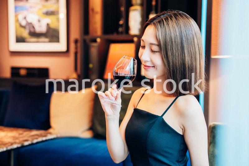 ラグジュアリーな雰囲気のお店で赤ワインを飲む若い女性