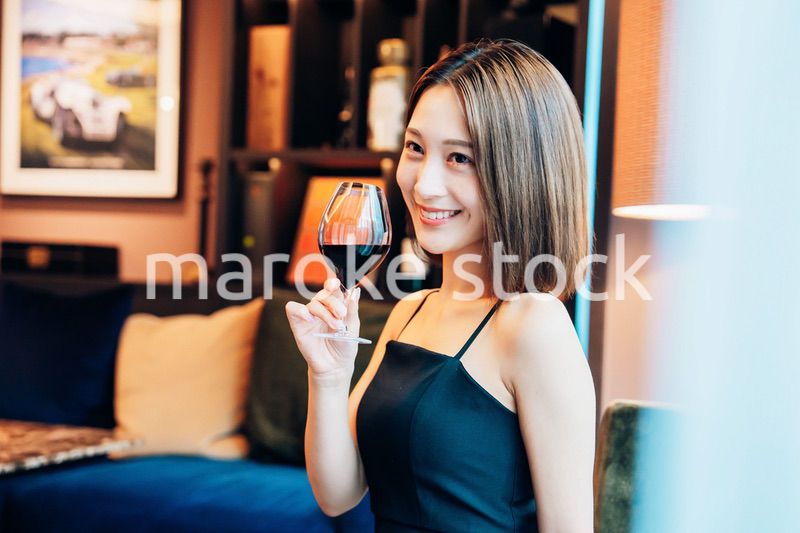 ラグジュアリーな雰囲気のお店で赤ワインを飲む若い女性