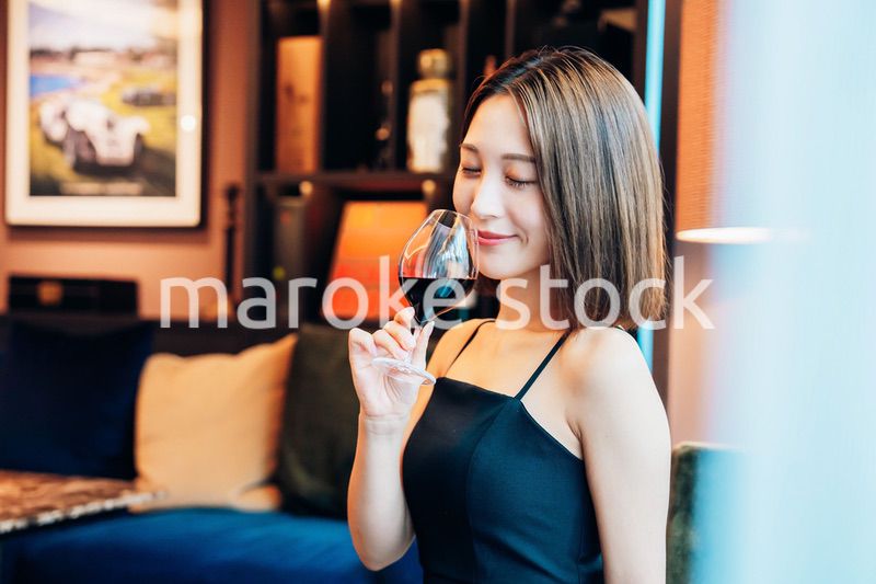 ラグジュアリーな雰囲気のお店で赤ワインを飲む若い女性