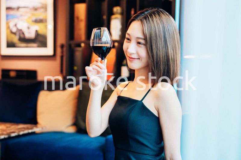 ラグジュアリーな雰囲気のお店で赤ワインを飲む若い女性